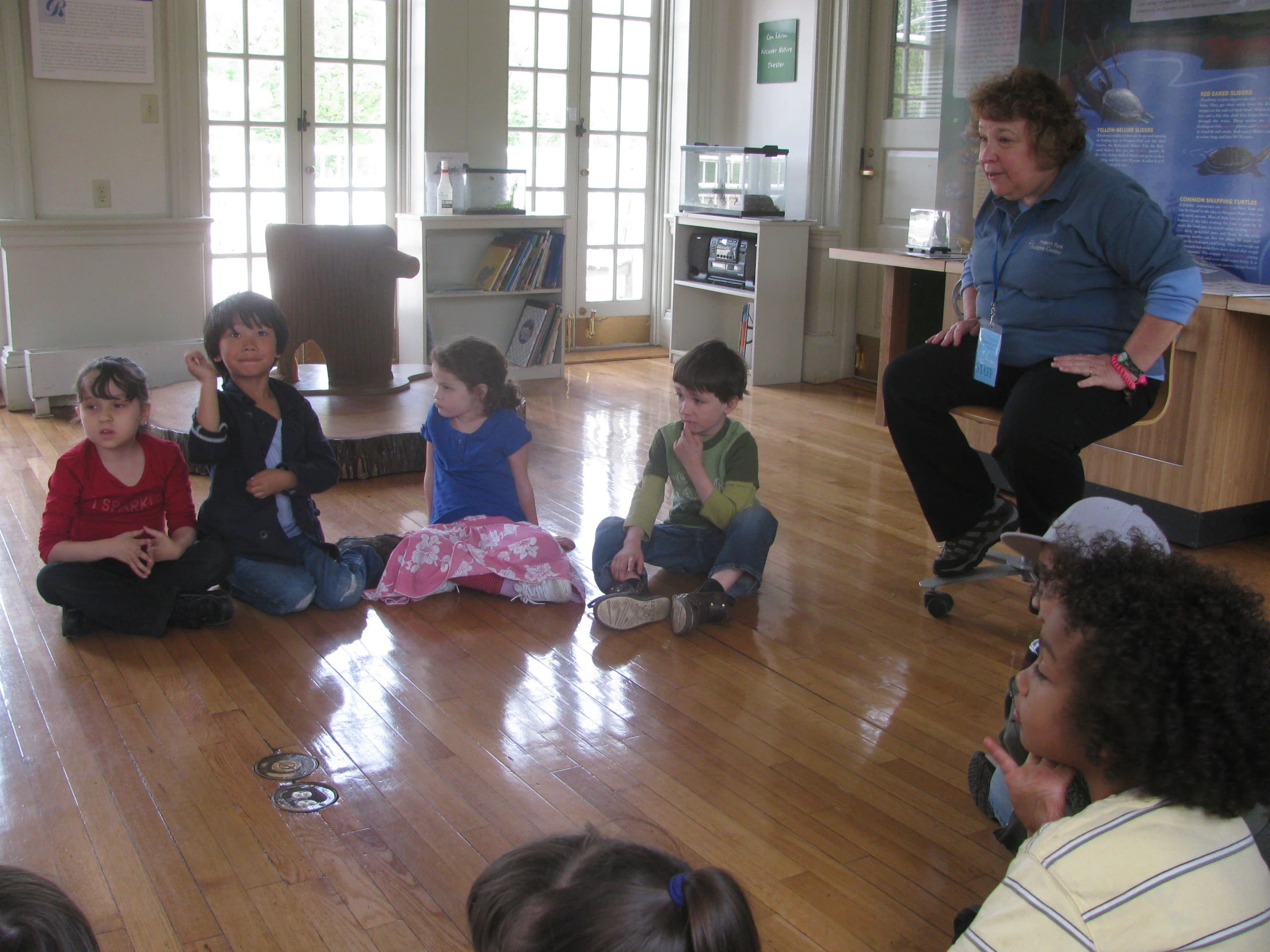 a group of children sit on the floor playing with toys