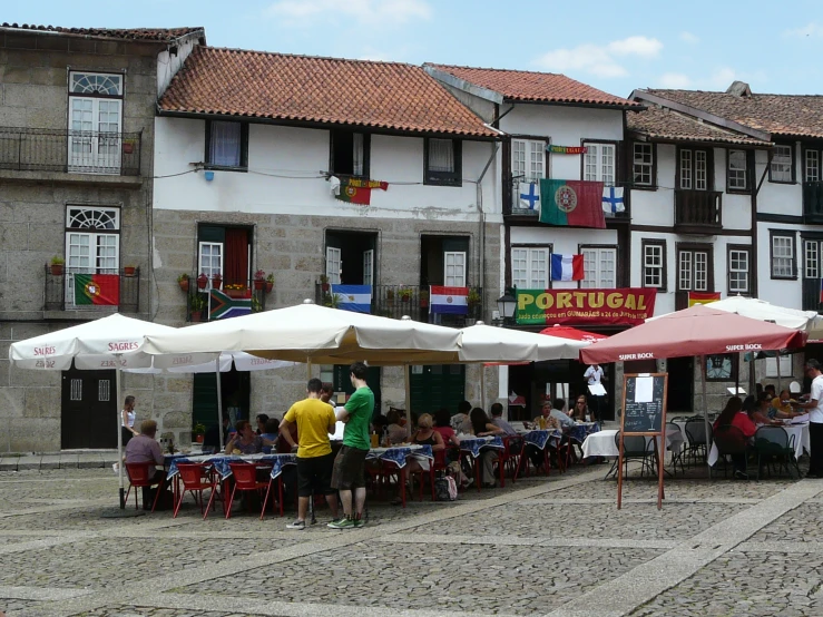 the people are eating outside in front of the restaurant