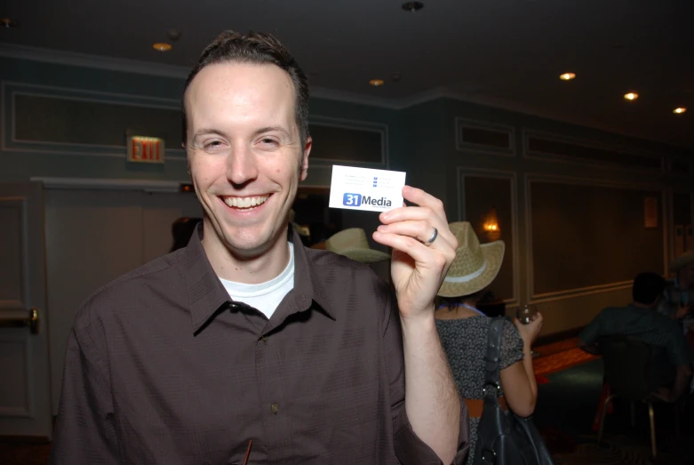 the man is smiling and showing off his name badge