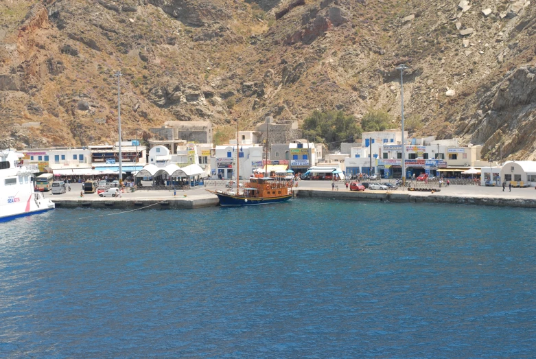 the boats are docked near the city by the mountains