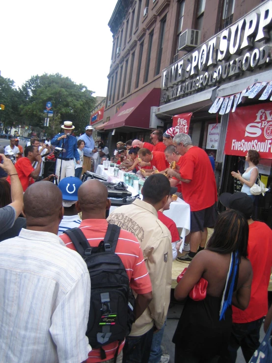 people are gathered at an outside event while several look on