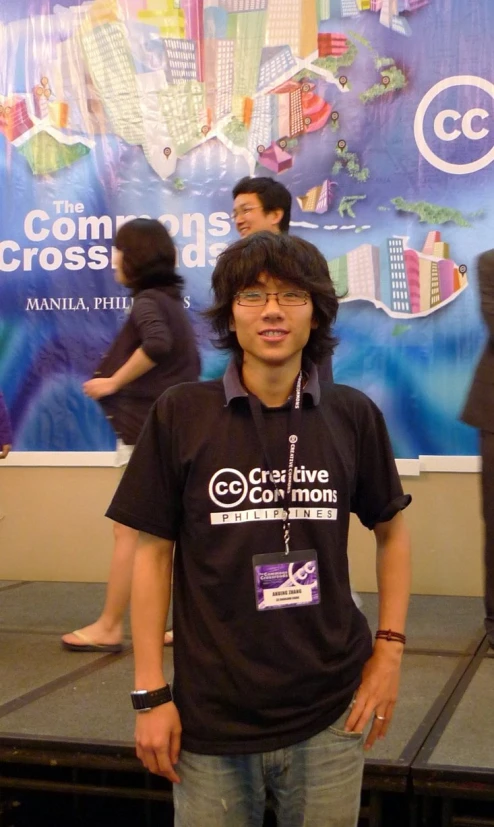 a man posing in front of a blue and white sign