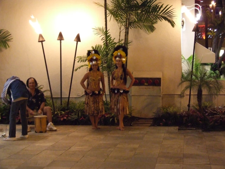 two dancers in costumes in front of a building with lights