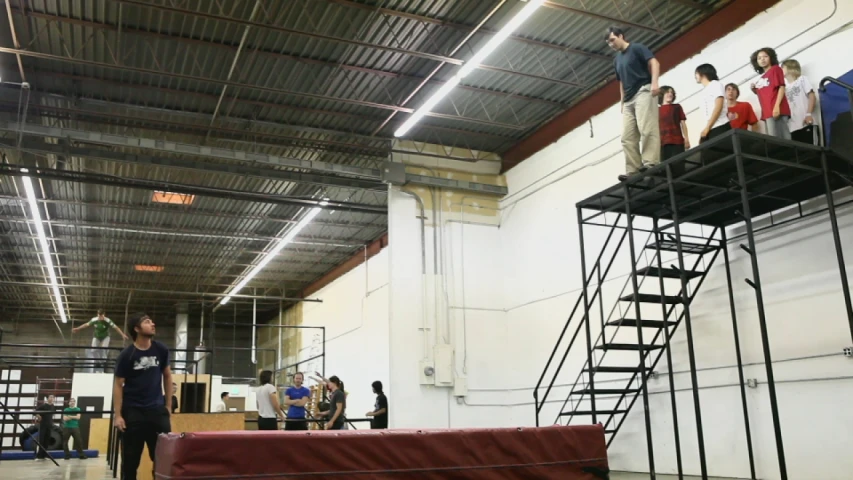 people are standing on a platform in a gym