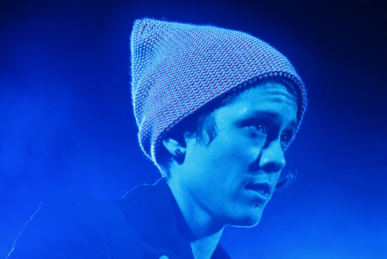 a man wearing a hat standing on top of a stage