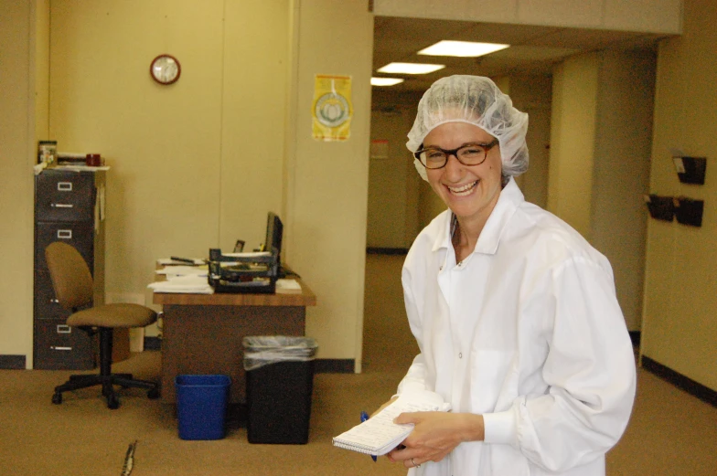 smiling female in lab coat and hat with white lab coat