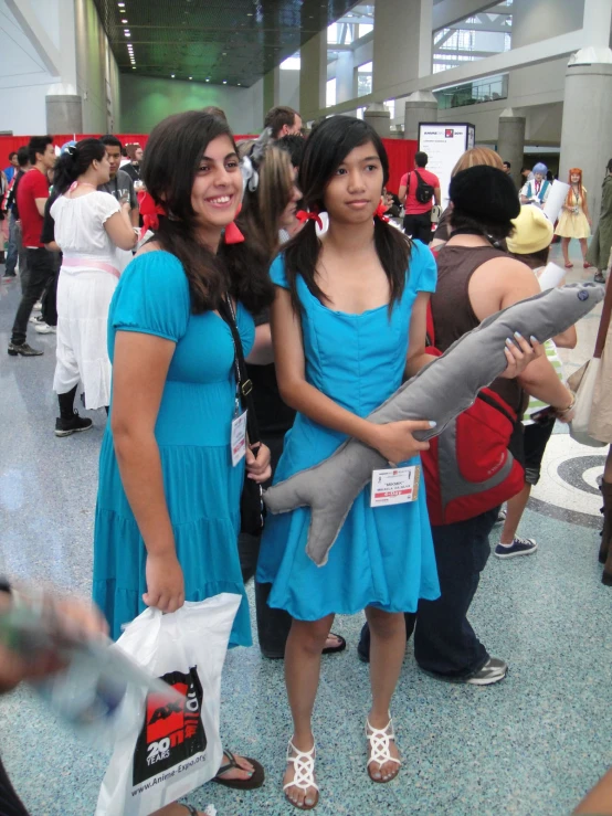 two women stand and talk inside an airport