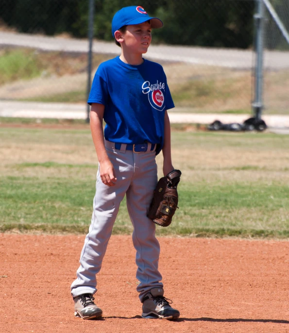 boy standing on the field with his glove