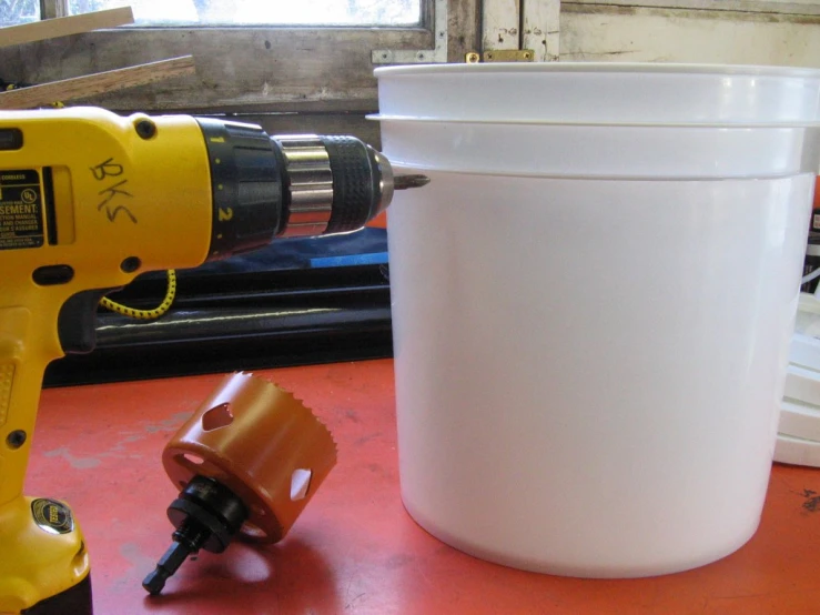 a drill attachment is used to fill a bucket with glue