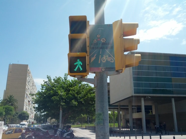 a sign on the corner of a road that has a green pedestrian symbol