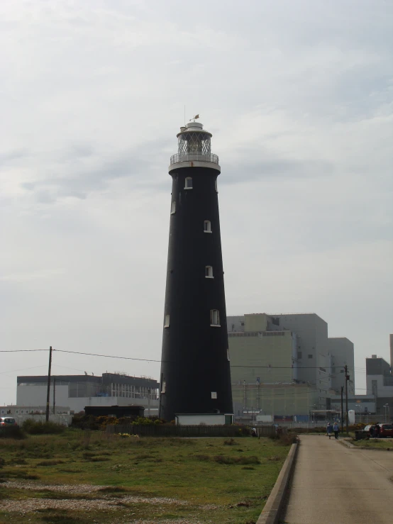 there is a large black tower in the middle of a grassy field