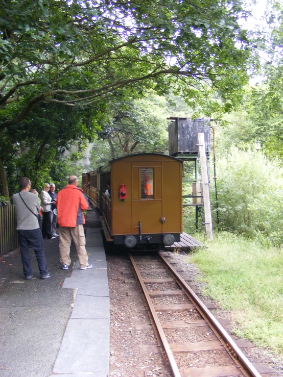 a small train stopped on the tracks at a station