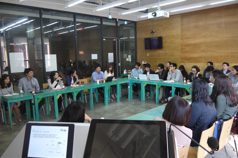 several people are in chairs with computers on the tables