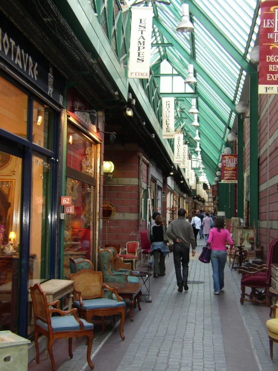 a woman walking down a street filled with furniture