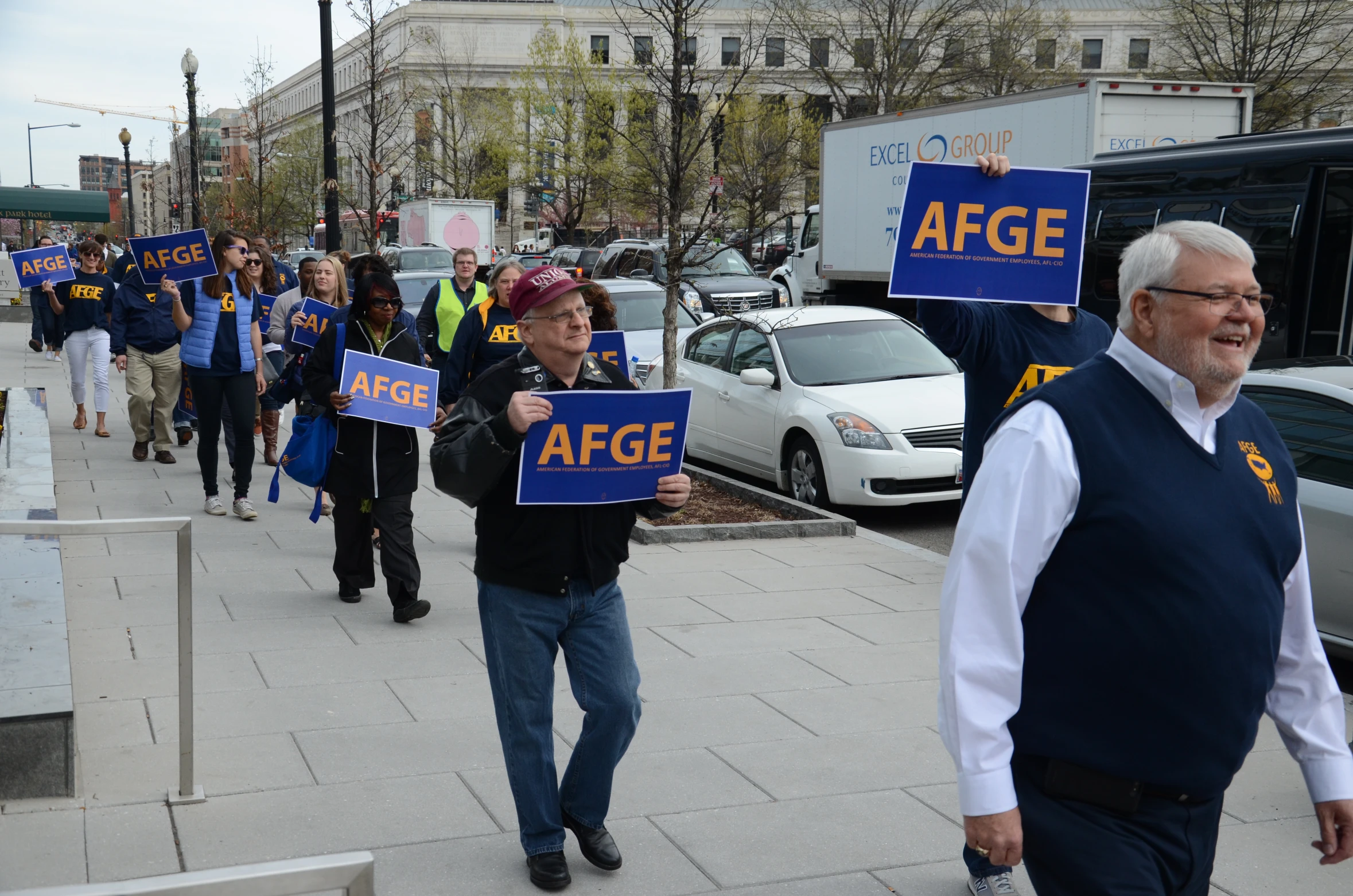 people march down a busy city street with signs