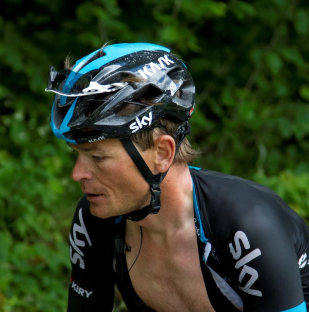 a man riding a bike in front of some trees