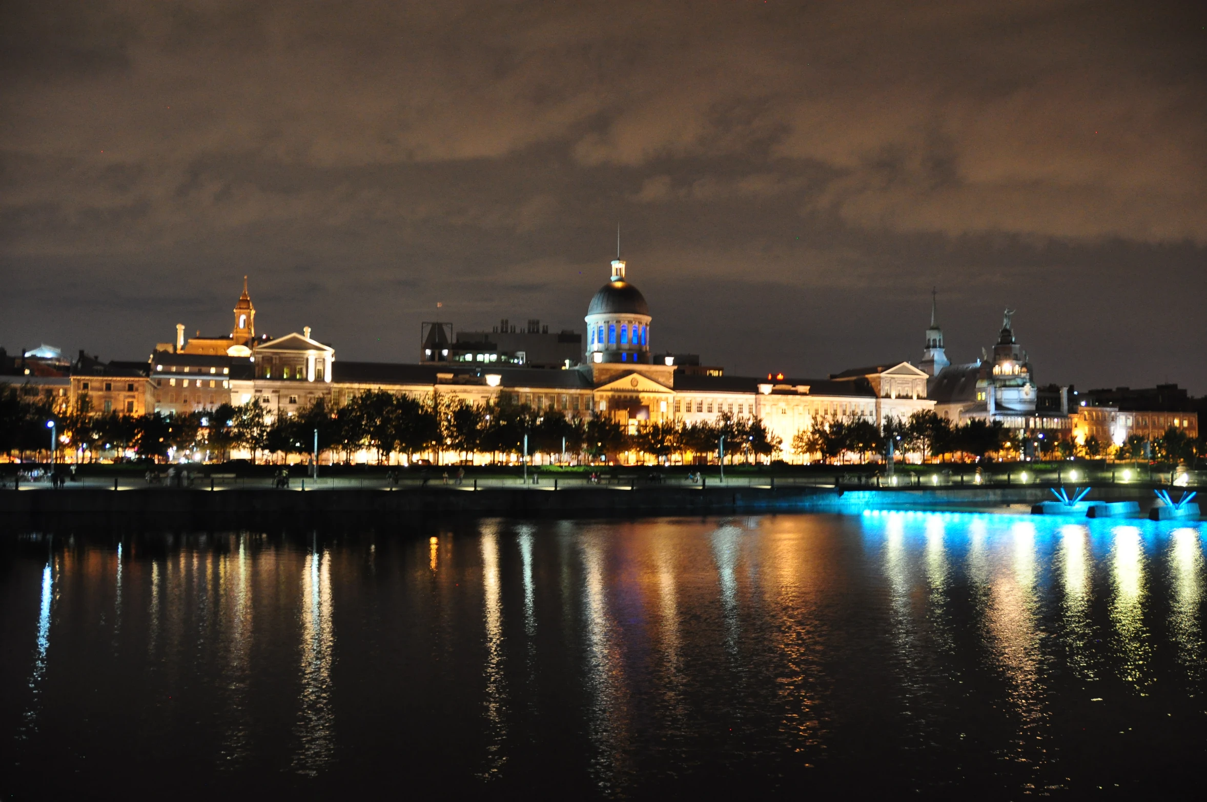 night scene of a town with many lights, buildings and large body of water