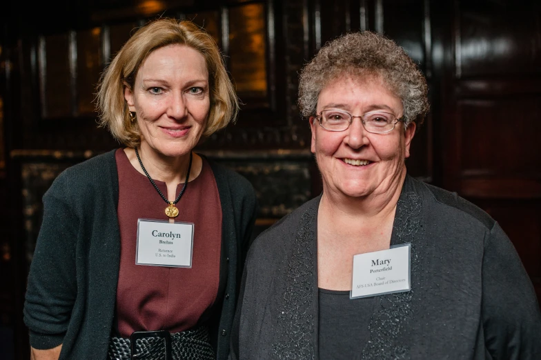 two women standing next to each other smiling