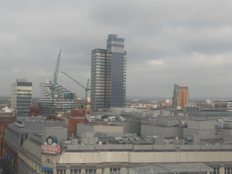 an industrial building stands near a skyscr, and looks down on a construction area