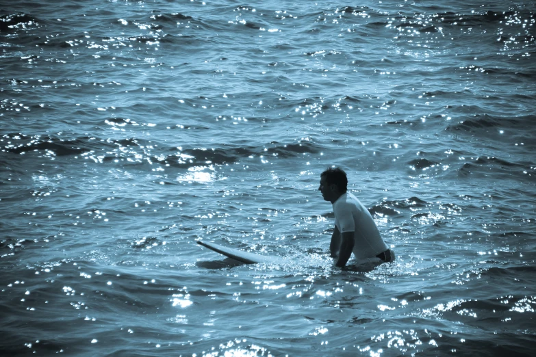 a man standing in the water with his surf board