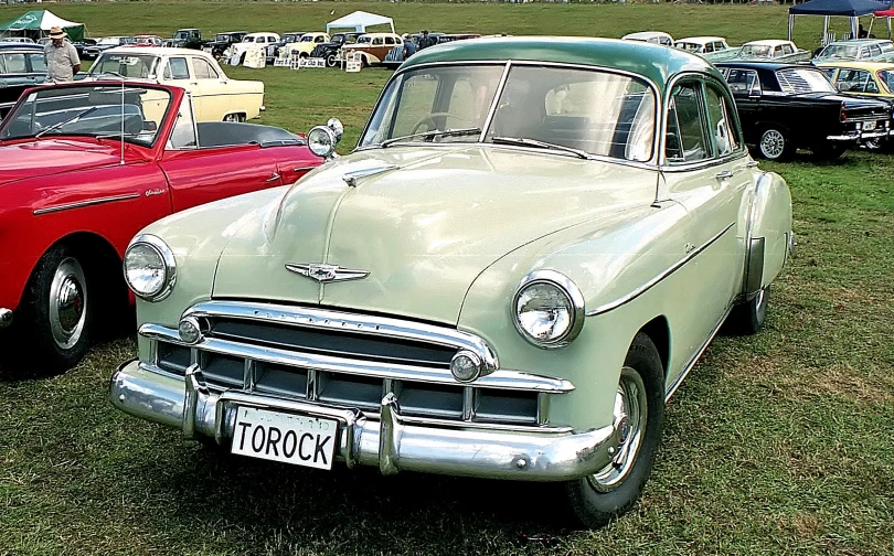 two classic cars parked side by side at a car show