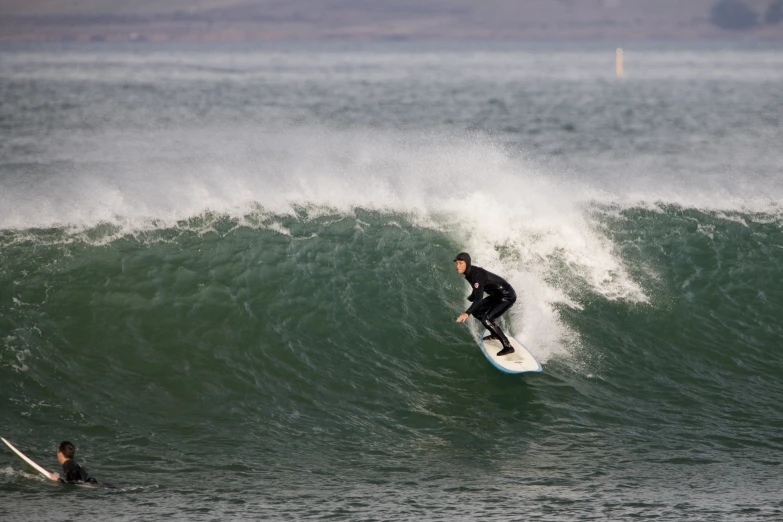 a surfer wearing a wet suit riding a wave