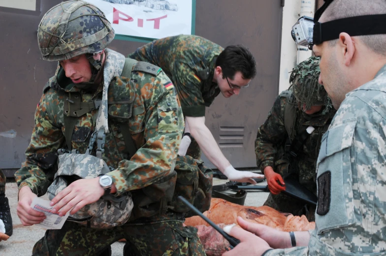 some soldiers with their hands in a meat donation bin