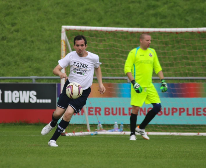 two men on a field playing soccer with the ball