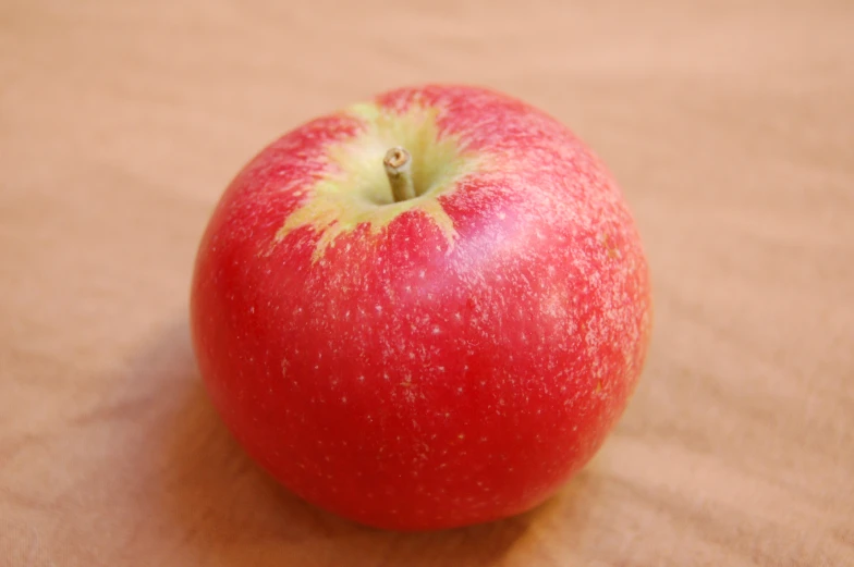 a red apple with green leafy tip on it