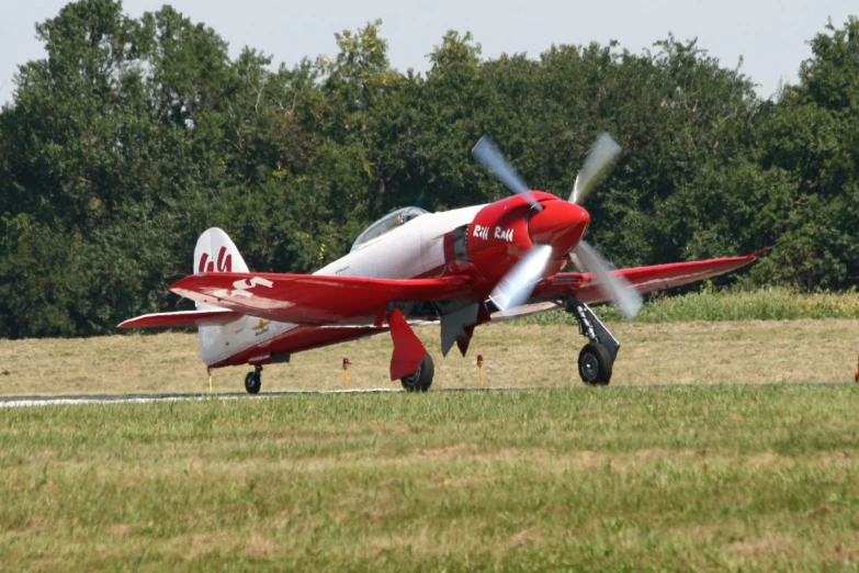 a small red and white plane on the ground