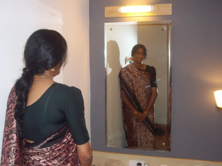 a woman standing in front of a mirror