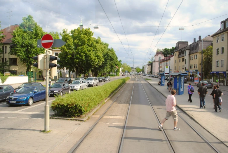 a woman that is walking down a street with some cars