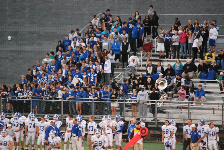 a football team that is standing in front of a crowd