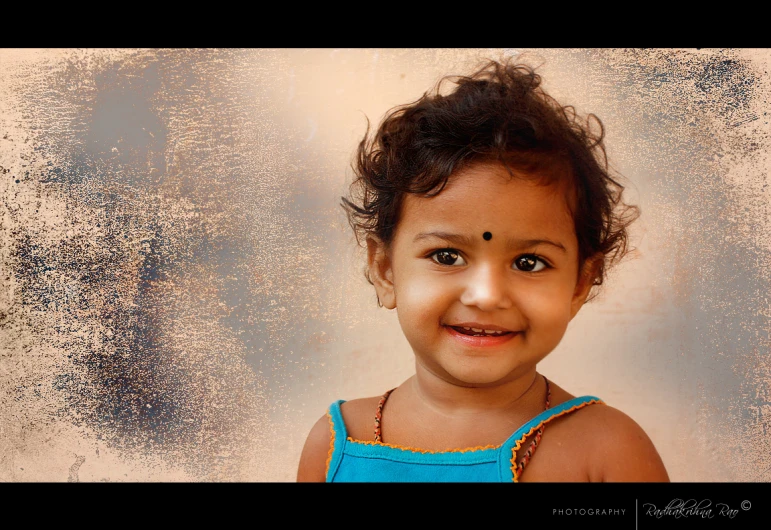 a child wearing a blue dress smiles for the camera