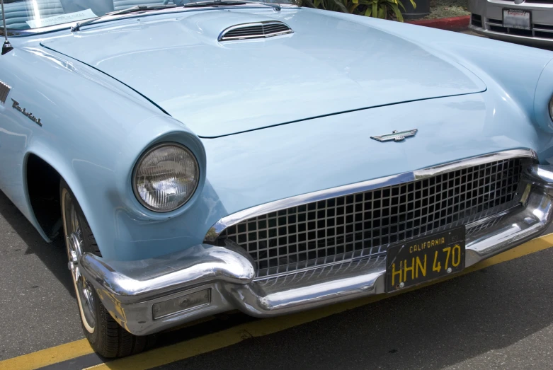 a blue old car sitting on the street