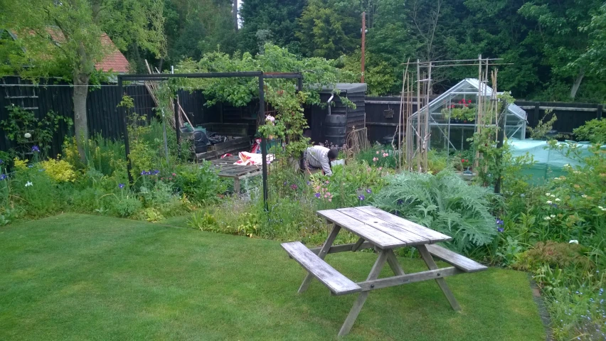 there is a picnic table in the yard by a bench