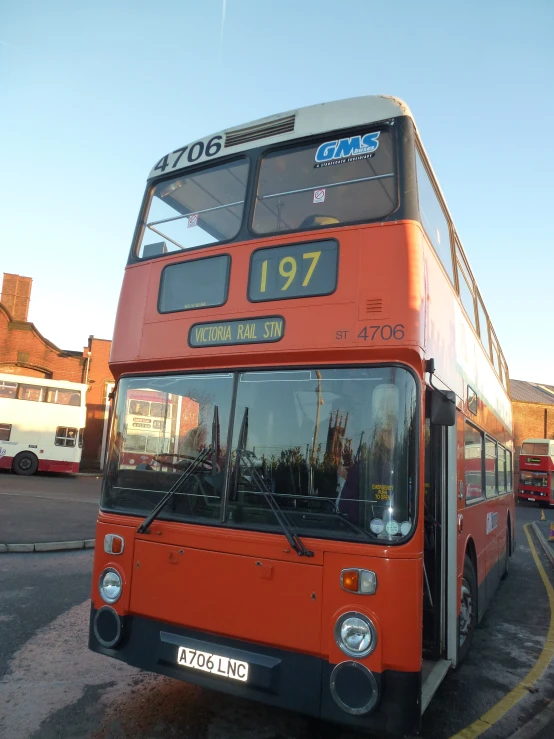 a large double decker bus driving through a parking lot