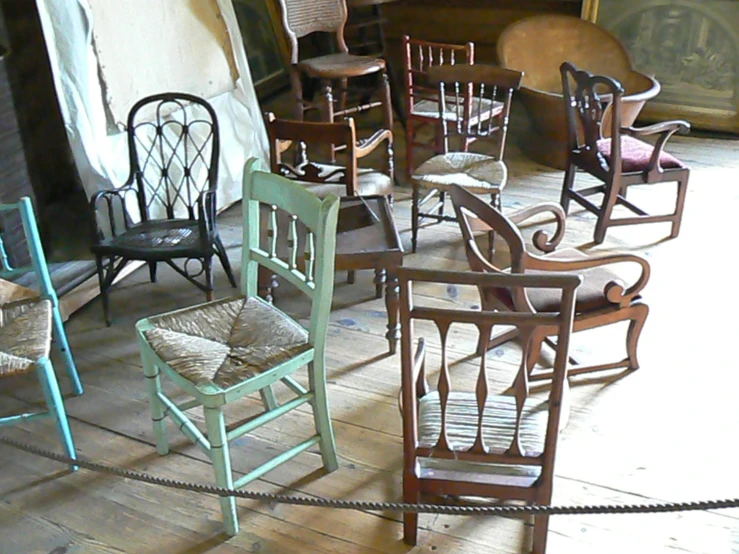 many wooden chairs are stacked in an old style house