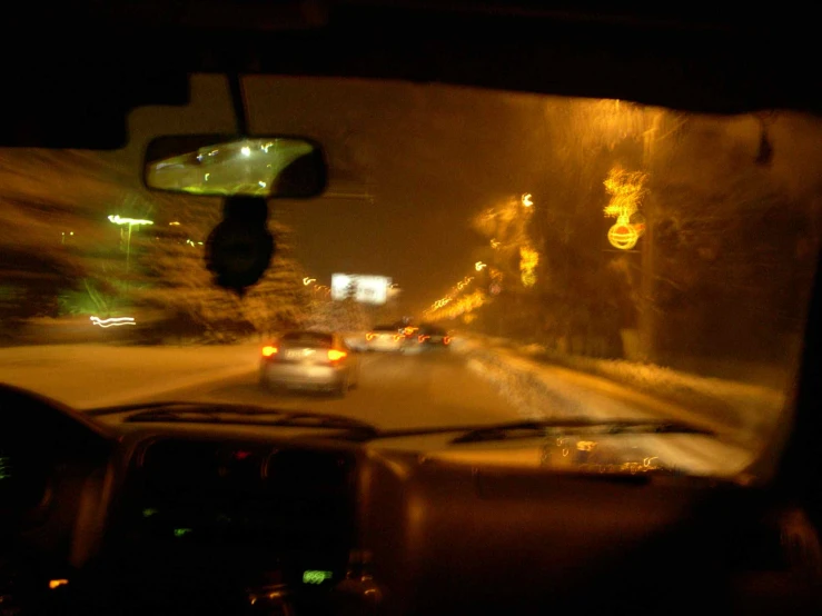 a picture taken from inside the vehicle of a car driving in the rain