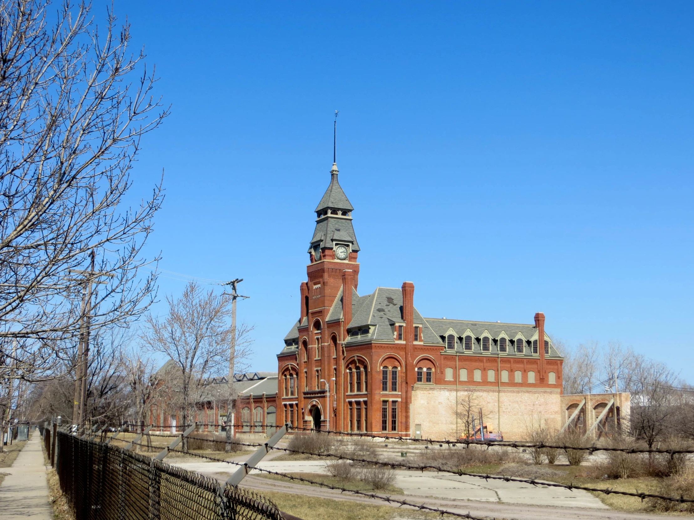 a very large old building near a brick fence