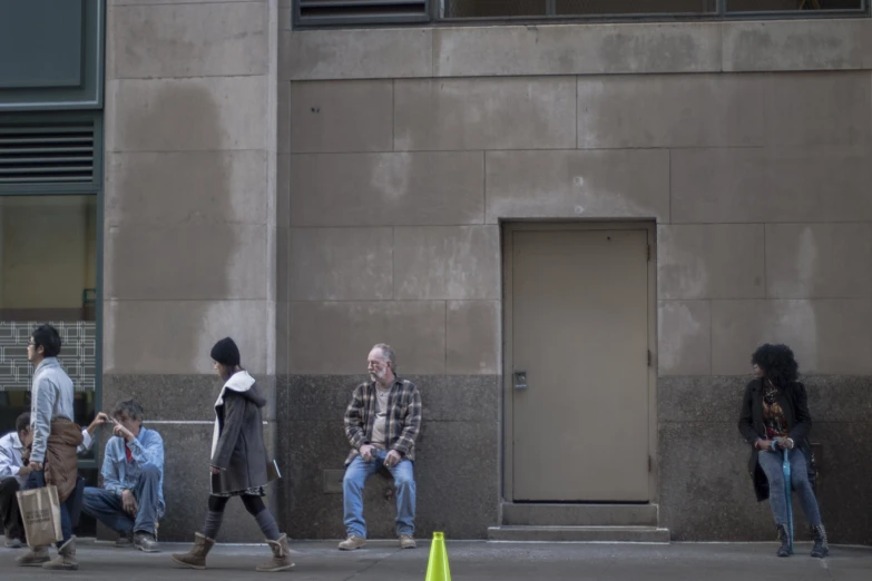 people walk past an entrance to a building