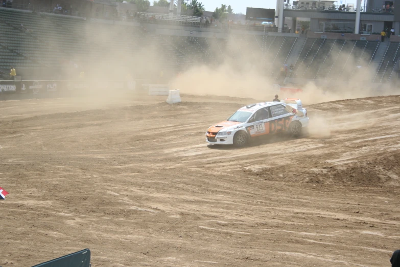 a person driving in a dirt car during an event