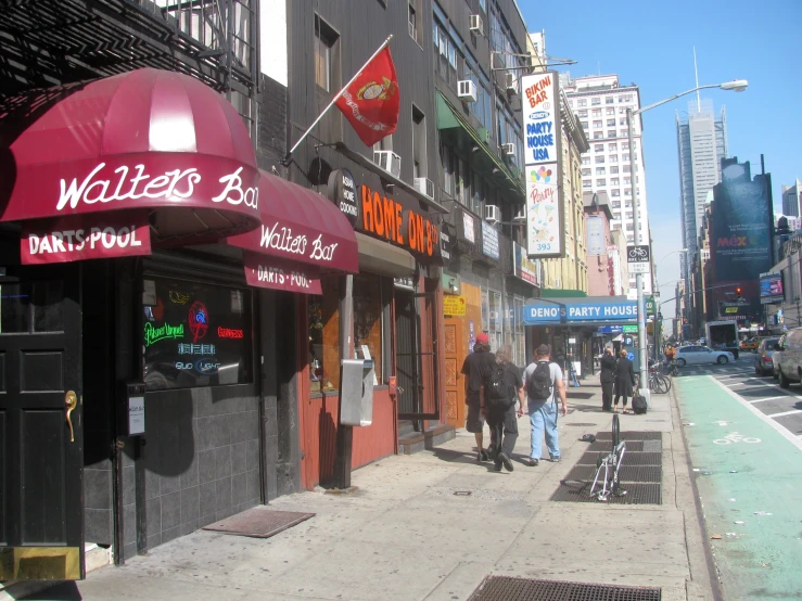 people walking on a sidewalk in the city