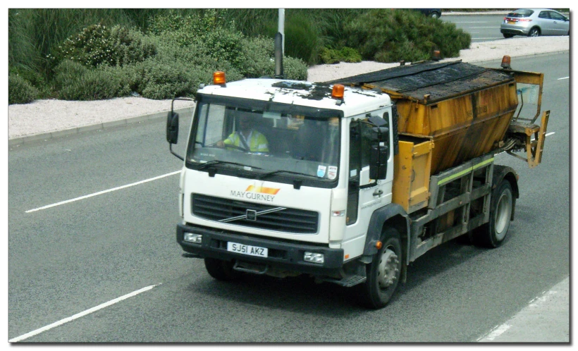 the construction truck is moving down the street