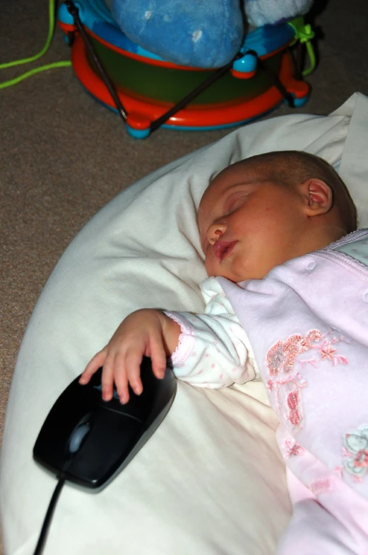 a baby is sleeping while holding the mouse