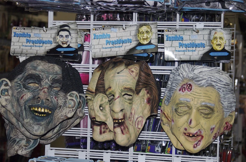 several fake masks hanging in a store window