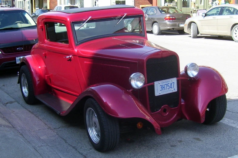 a red pick up truck sitting next to other cars