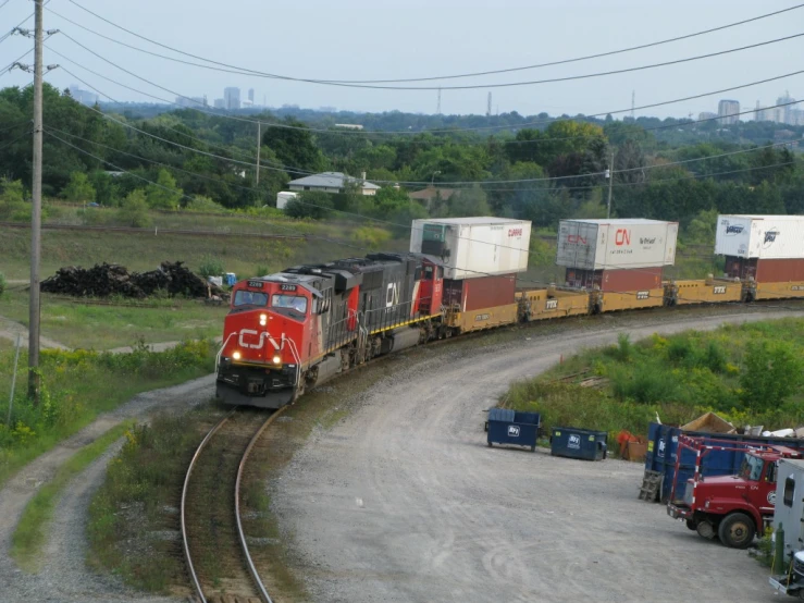 train pulling cargo down the track through an urban area