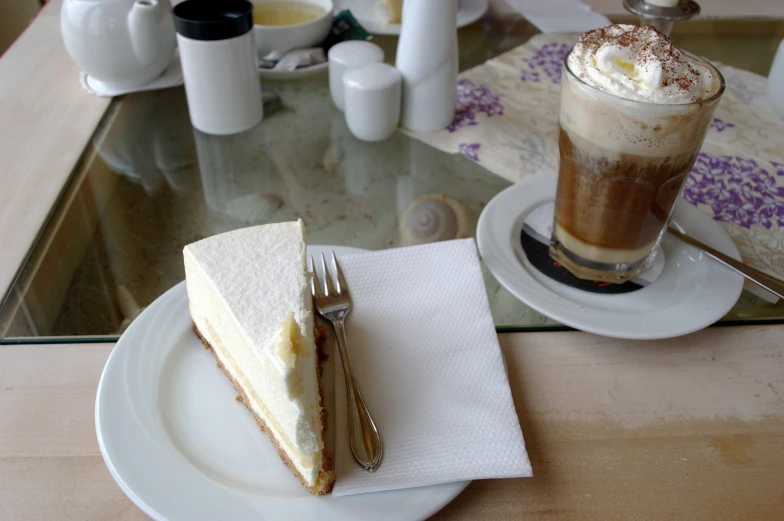 a slice of cake on a plate next to a drink