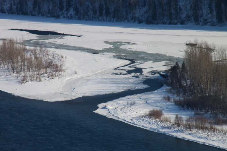 the road is winding through the snow and frozen water